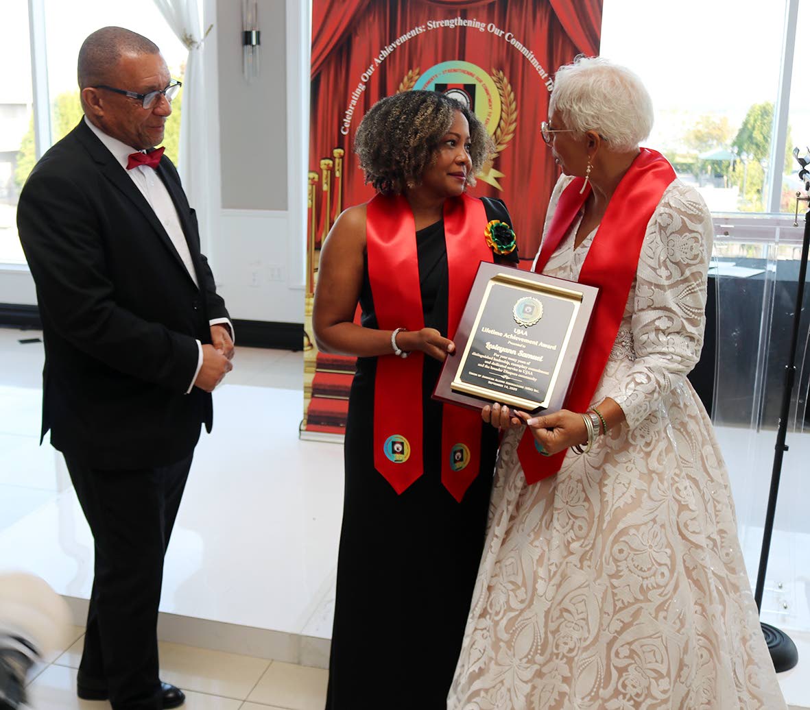 Minister of Education, Skills, Youth and Information, Dr Dana Morris Dixon presents Lesleyann Samuel with the 2025 Union of Jamaica Alumni Association Lifetime Achievement award. 