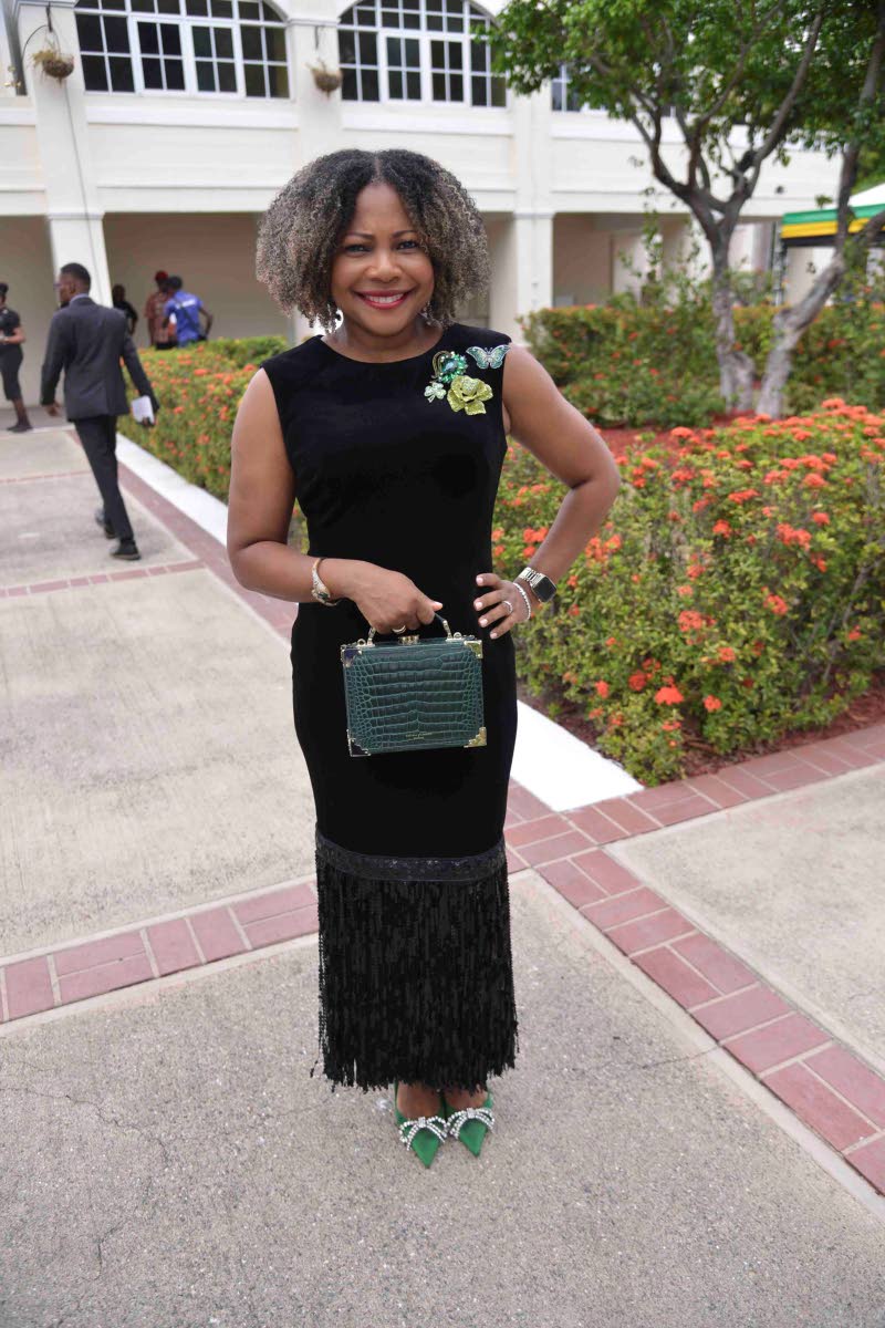 Senator Dr Dana Morris Dixon makes a strong statement in a black velvet midi dress with a tasselled hem, pairing the look with emerald accents.