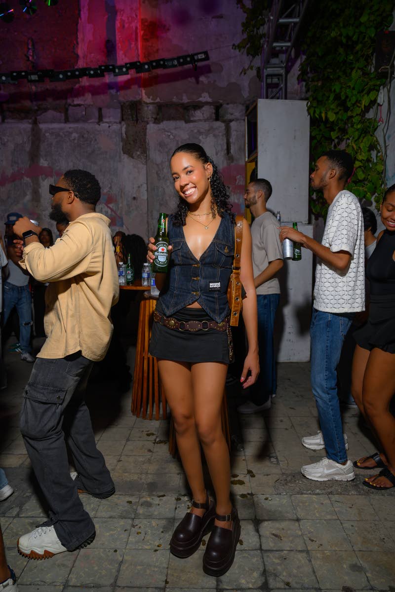 Danielle Morris rocks a denim vest and black mini skirt, complemented by a cowboy belt and platform shoes.