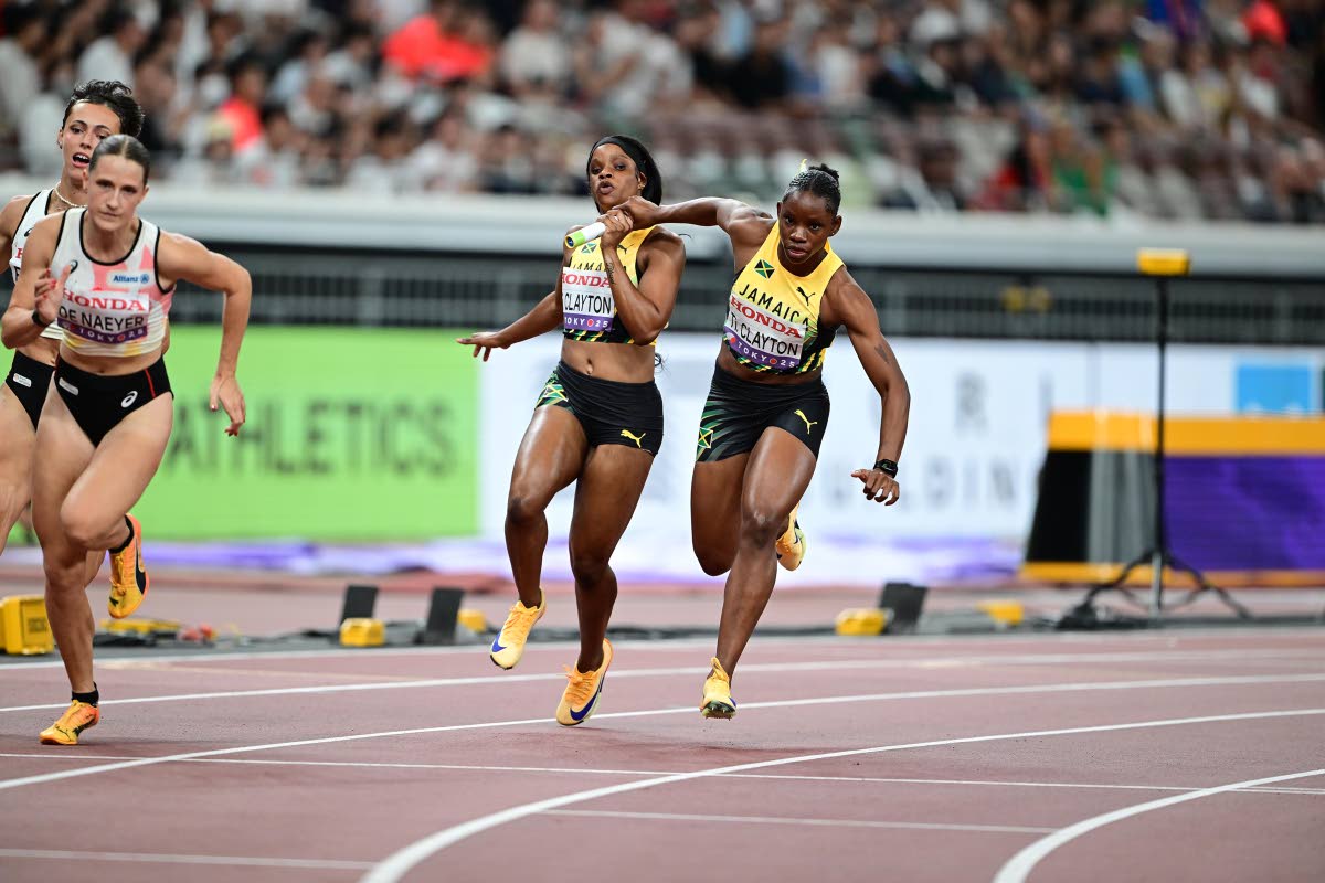 Tia Clayton (left) gets the baton safely to her sister Tina Clayton as Jamaica safely qualify for the final of the women’s 4x100-metre relay at the World Athletics Championships in Tokyo, Japan yesterday.