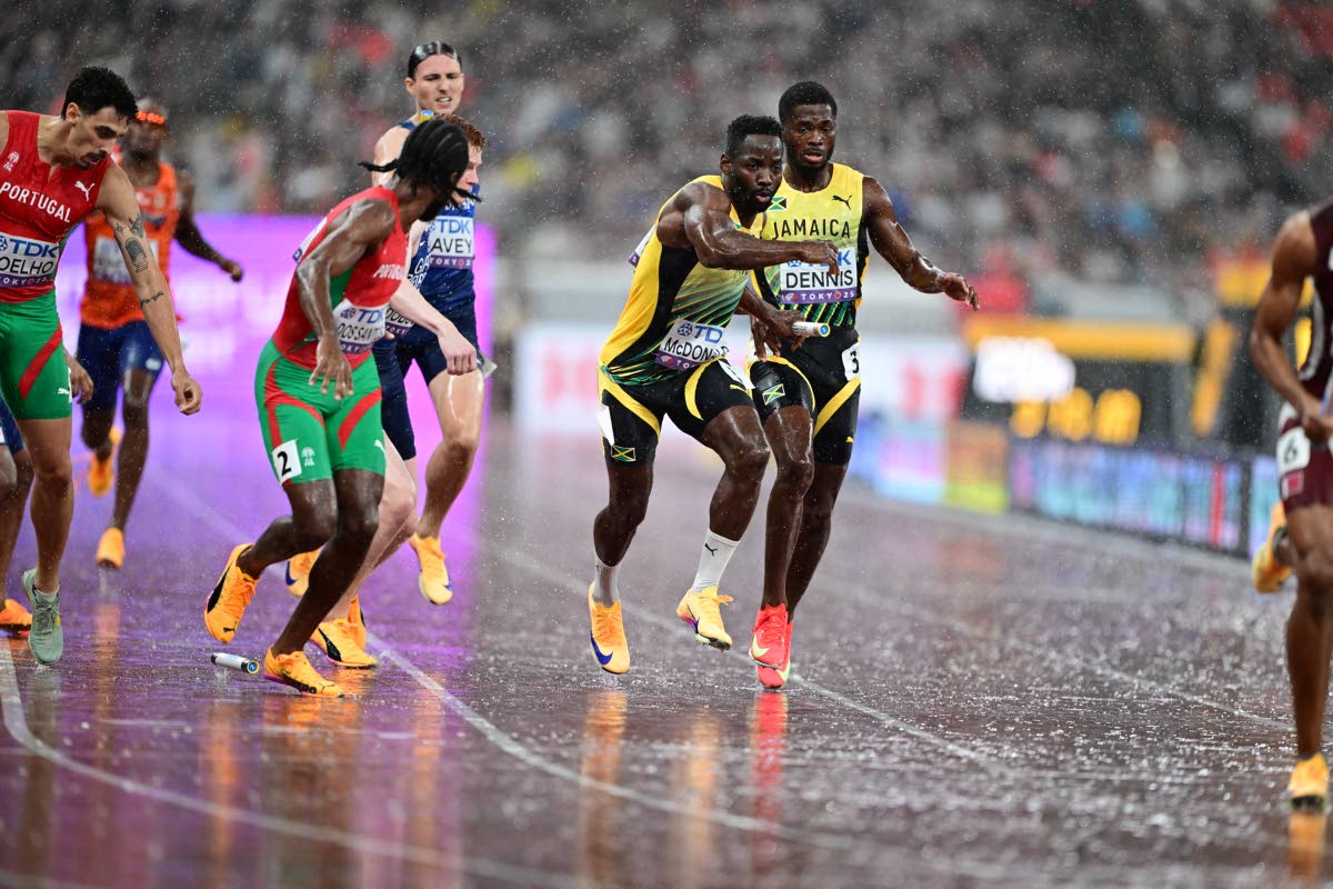 Jamaica’s Jashauna Dennis (right) hands over to Rusheen McDonald (second right) during the men’s 4x400-metre final at the World Athletics Championships in Tokyo, Japan, yesterday.  Jamaica finished seventh in 3:03.46.