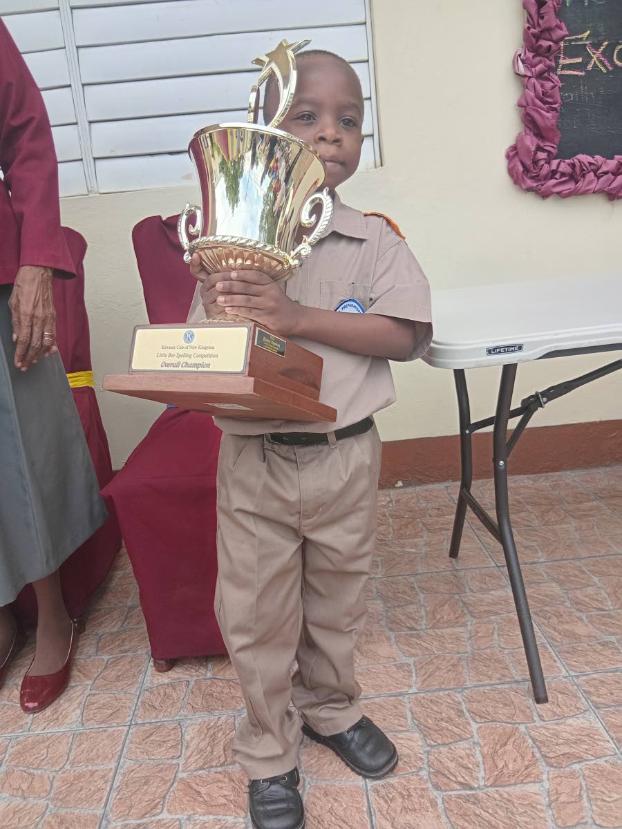 Winner of the Kiwanis Club spelling competition posing with his trophy.