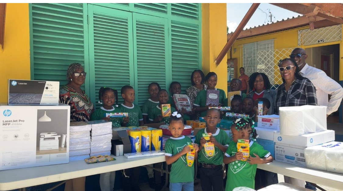 Retired educator Rhona Campbell (left), Dr Dawn Lemonius (second right) and retired Assistant Commissioner of Police Denver Frater (right) were all smiles as they handed over goodies to staff and students at the Ulster Spring Primary and Infant School.