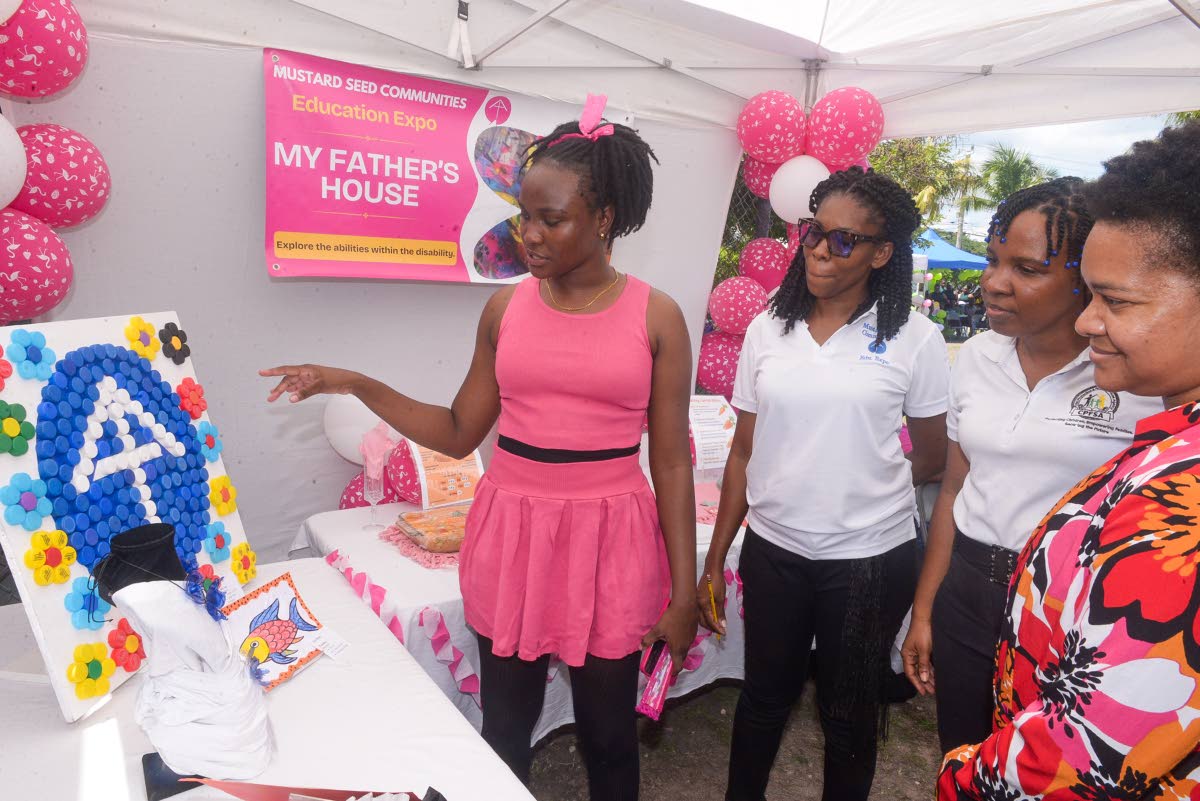 Special needs coordinator at the Ministry of Education, Skills, Youth and Information, Nicolette Thompson (right), and children’s officer at the Child Protection and Family Services Agency (CPFSA), Jesanya Scale-Menzies (second right), view a recycled wa