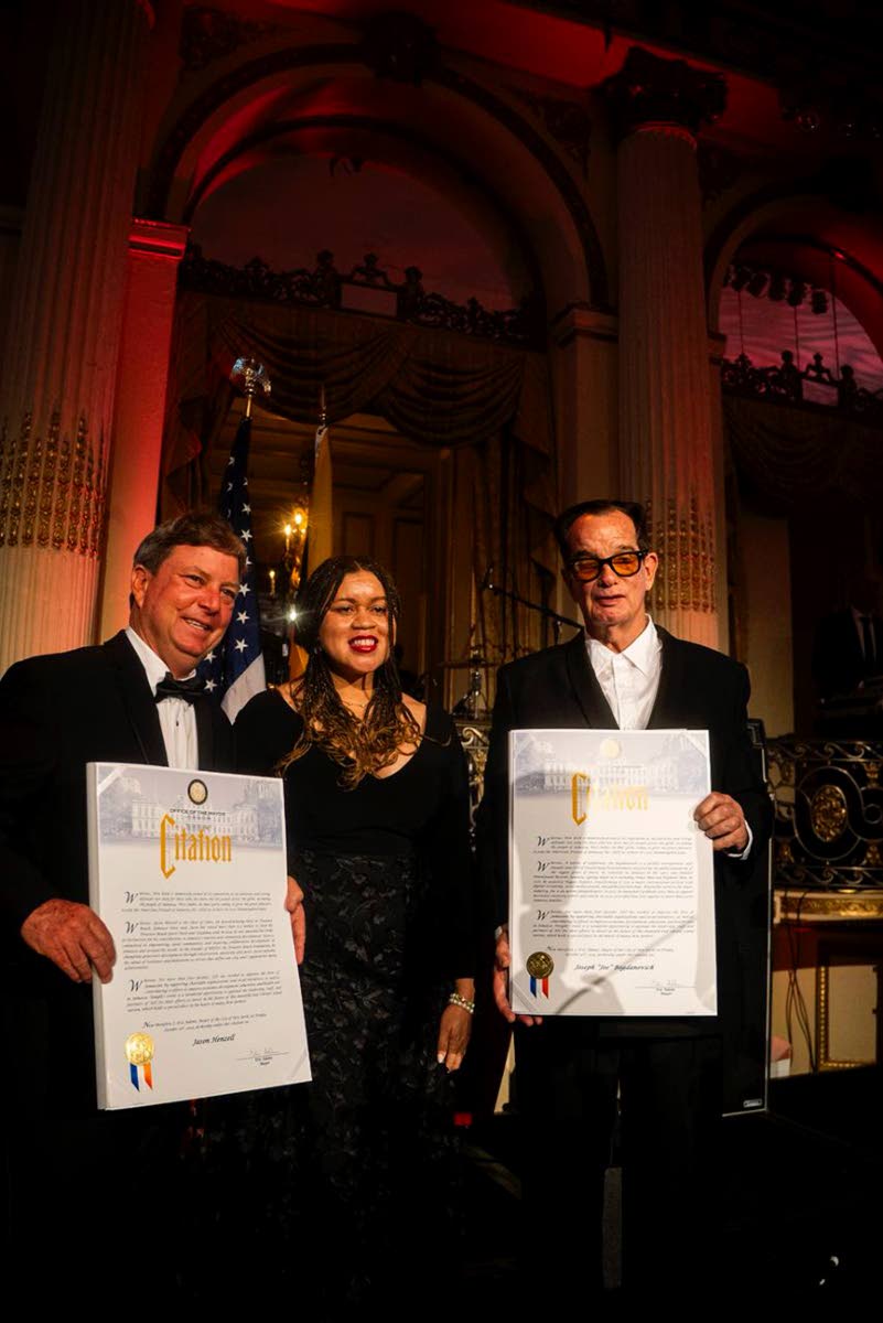 Jason Henzell (left) and Josef Bogdanovich receive their citations from Tiffany Raspberry, deputy mayor for intergovernmental affairs in New York. 