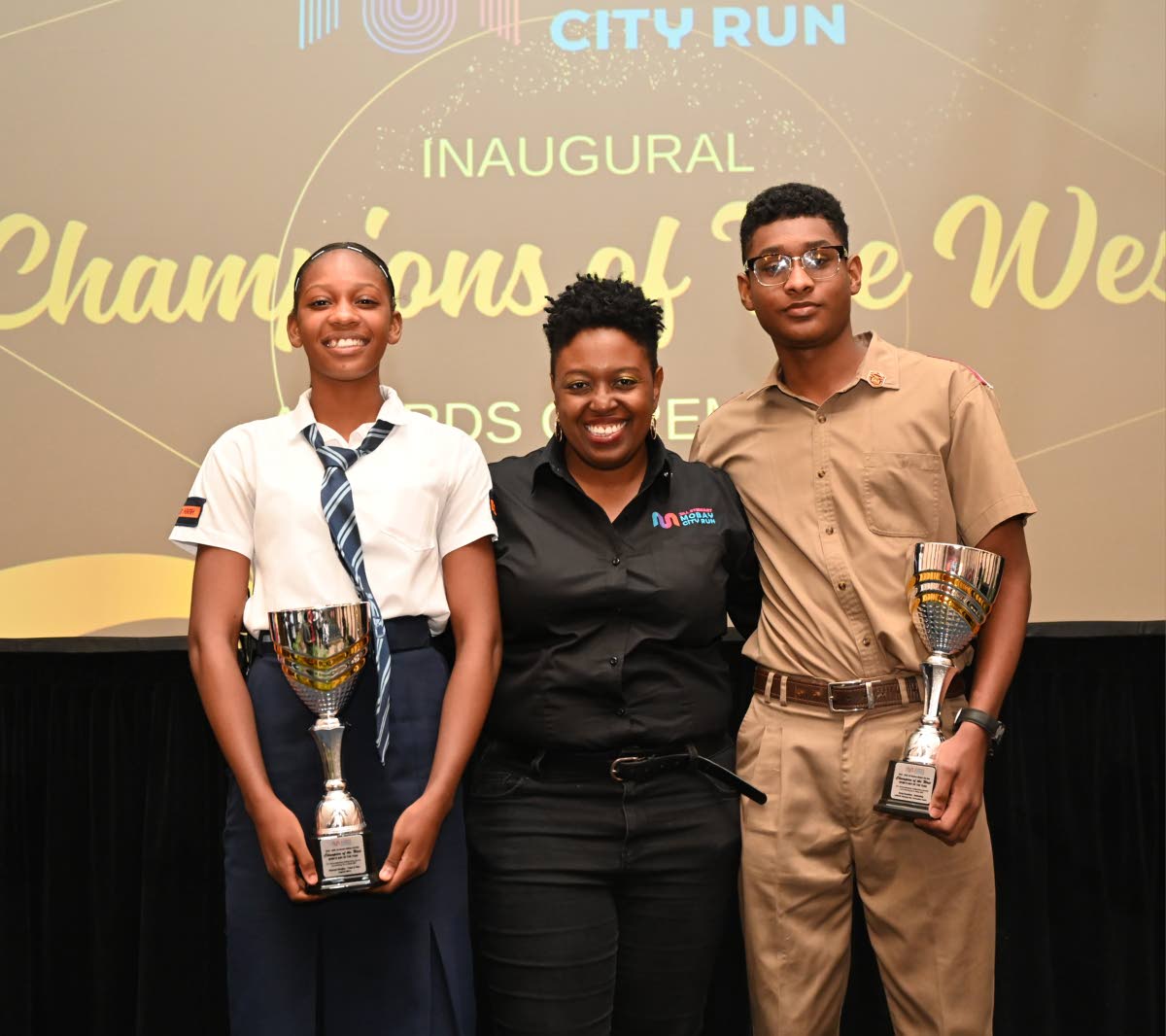 Ashley Anguin, Chairperson, Jill Stewart MoBay City Run Champions of the West committee (centre) is flanked between Shanoya Douglas, Sports Girl of the Year for Track & Field from Holland High School, and Suraj Guwalani, Sports Boy of the Year for Swimming