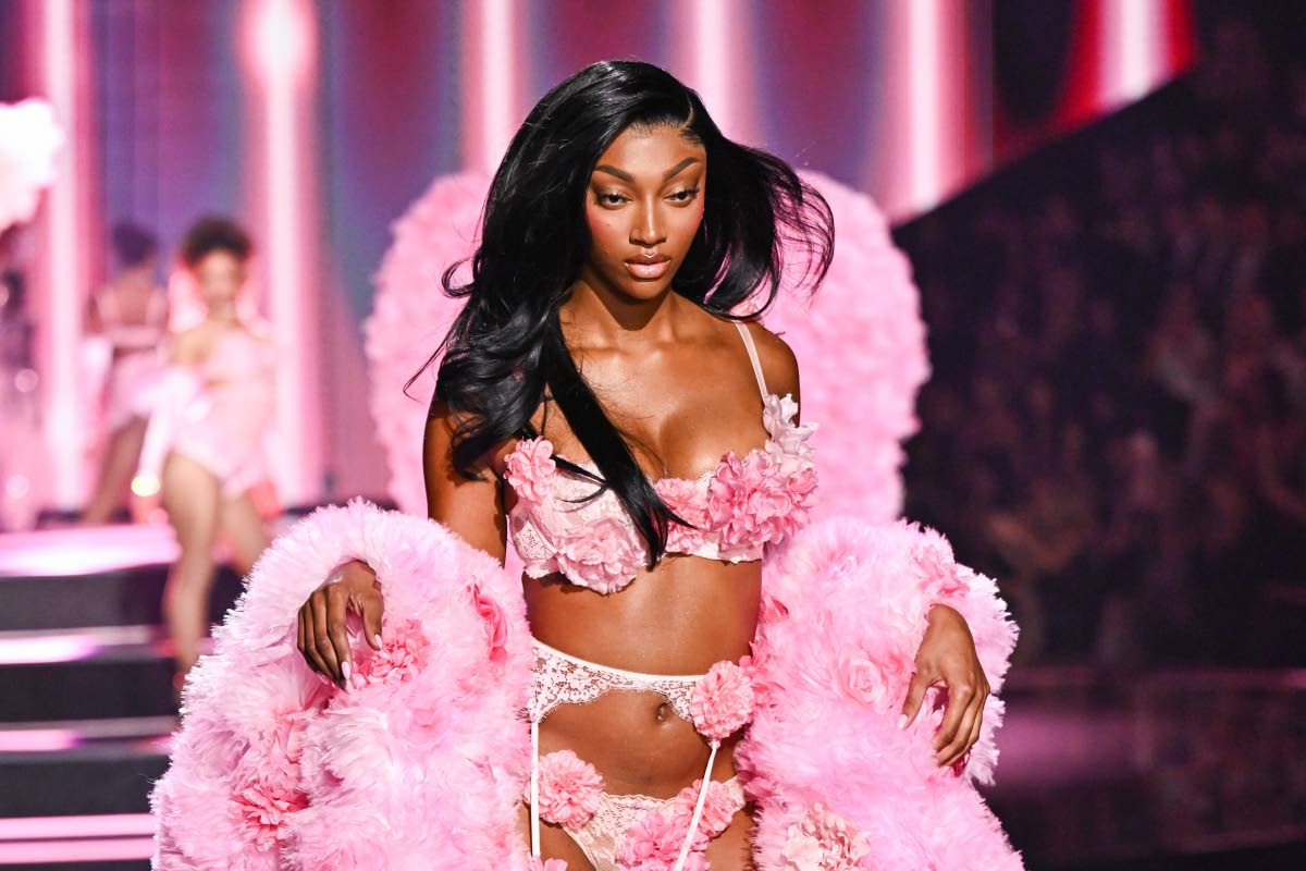 Angel Reese’s pink floral lingerie set was paired with a dramatic feathered stole draped across her arms. 