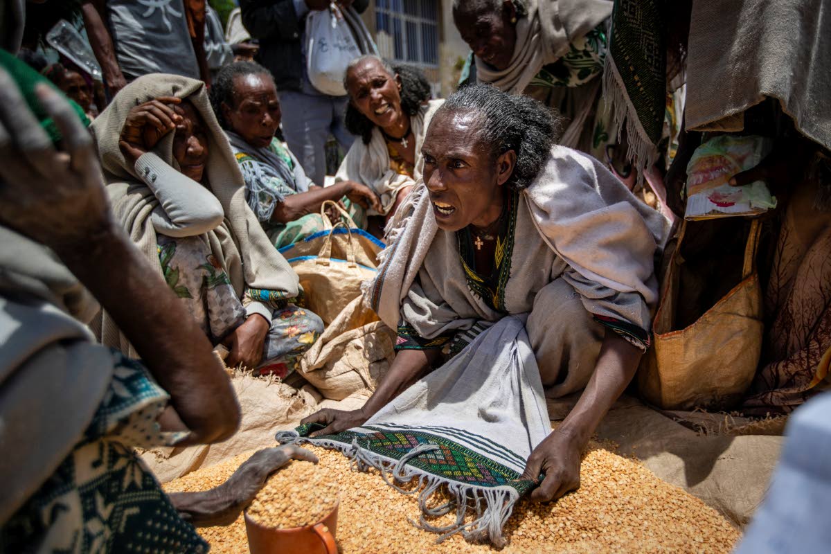 In this 2021 photo a woman is seen arguing with others over the allocation of yellow split peas after it was distributed by the Relief Society of Tigray in the town of Agula, in the Tigray region of northern Ethiopia.