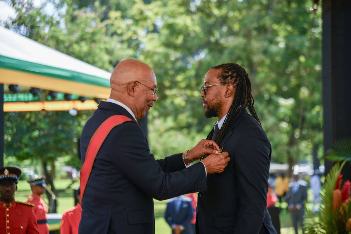 Ricardo ‘Bibi’ Gardner (right) recieves the Order of Distinction at the Ceremony of Investiture and Presentation of National Honours and Awards held on the lawns of King’s House on National Heroes Day, yesterday.