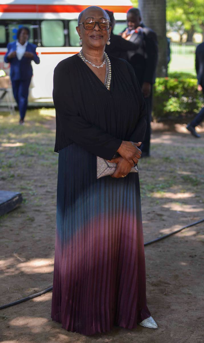 Iris James, wife of Lloyd ‘King Jammy’ James, legendary music producer, stands tall in an ombré multi-toned maxi with silver accessories, as she supports her husband who was conferred the Order of Distinction in the Commander class for his contributio