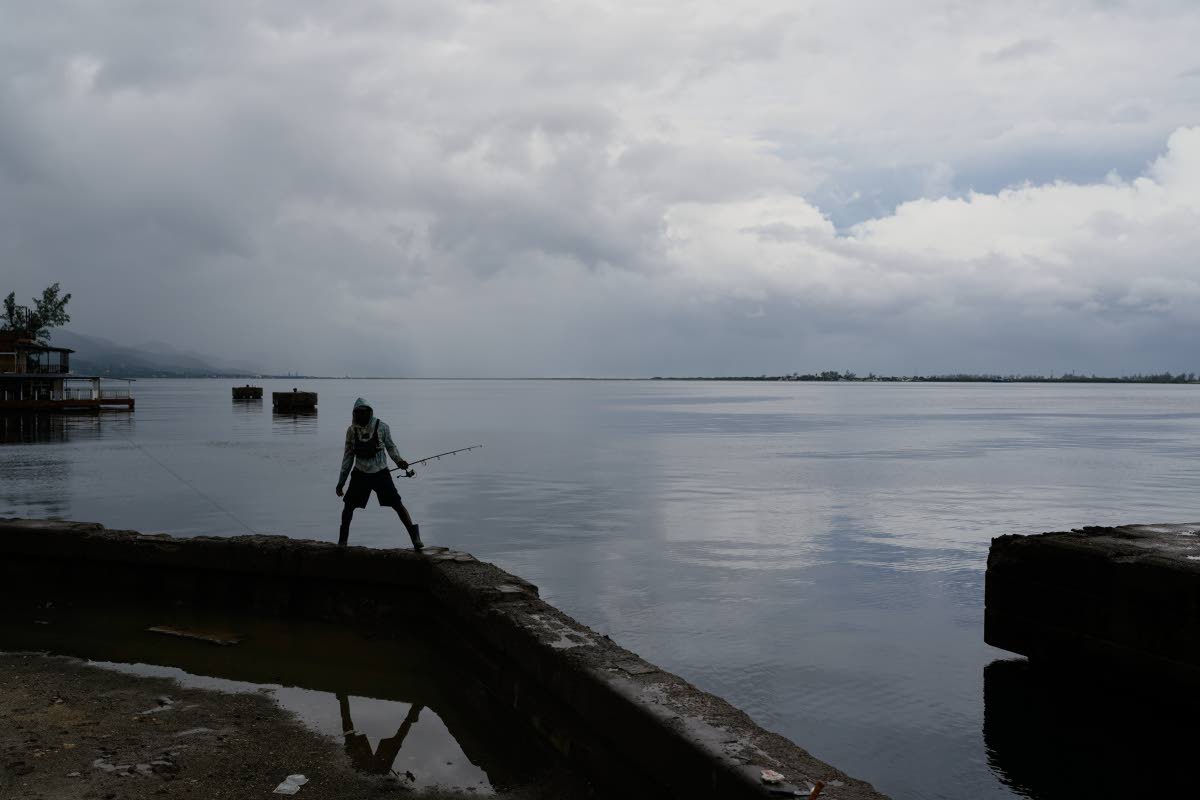 A man holds his fishing rod in Kingston, Jamaica.