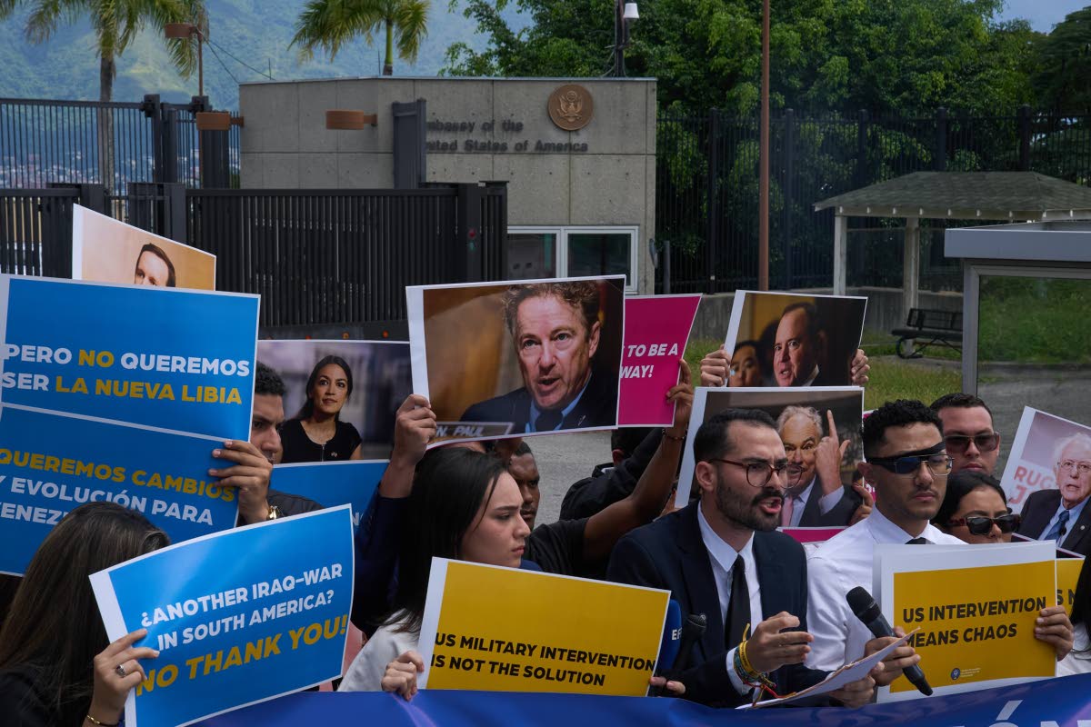Gabriel Cabrera, president of the Venezuelan Youth Center for Democracy, gives a statement outside of the US embassy with members of the organisation holding signs against US intervention, in reference to US warships operating in the Caribbean, in Caracas,