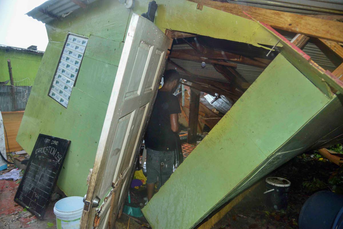Pernel Wright, a resident of Walker’s Avenue in Gregory Park, St Catherine, shows the extent of damage done to his house by a downed tree.