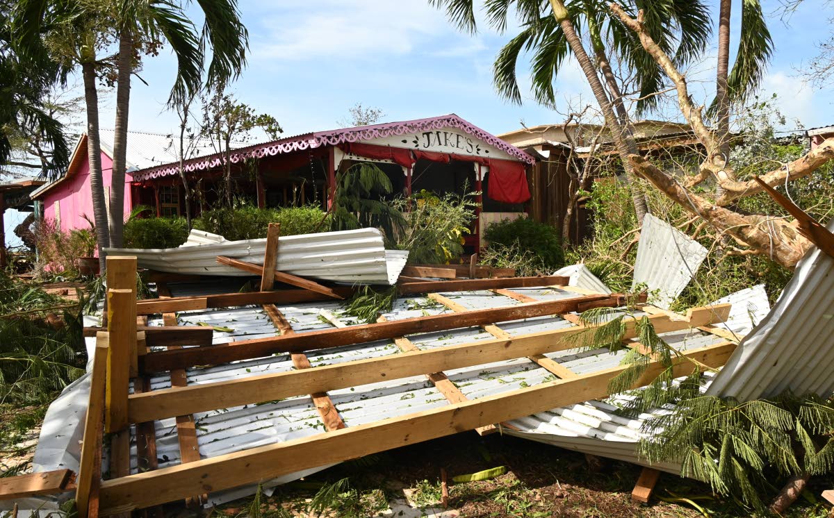 A zinc roof rests among the damage at Jakes after Hurricane Melissa.