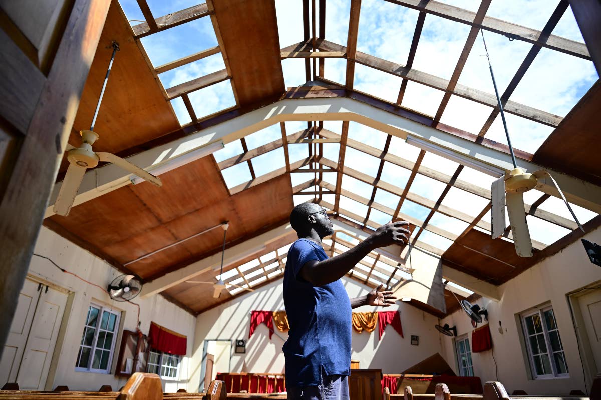 Sherman Graham, pastor at the Brucefield Gospel Chapel, surveys the damage inflicted upon the church by Hurricane Melissa. He expressed uncertainty as to when the congregation would gather again.