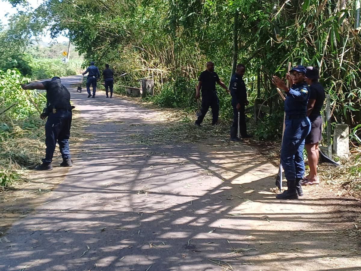 Officers attached to the Guanaboa Vale Police Station in St Catherine clear debris from the roadway caused by Hurricane Melissa, during a workday in the community on November 3.