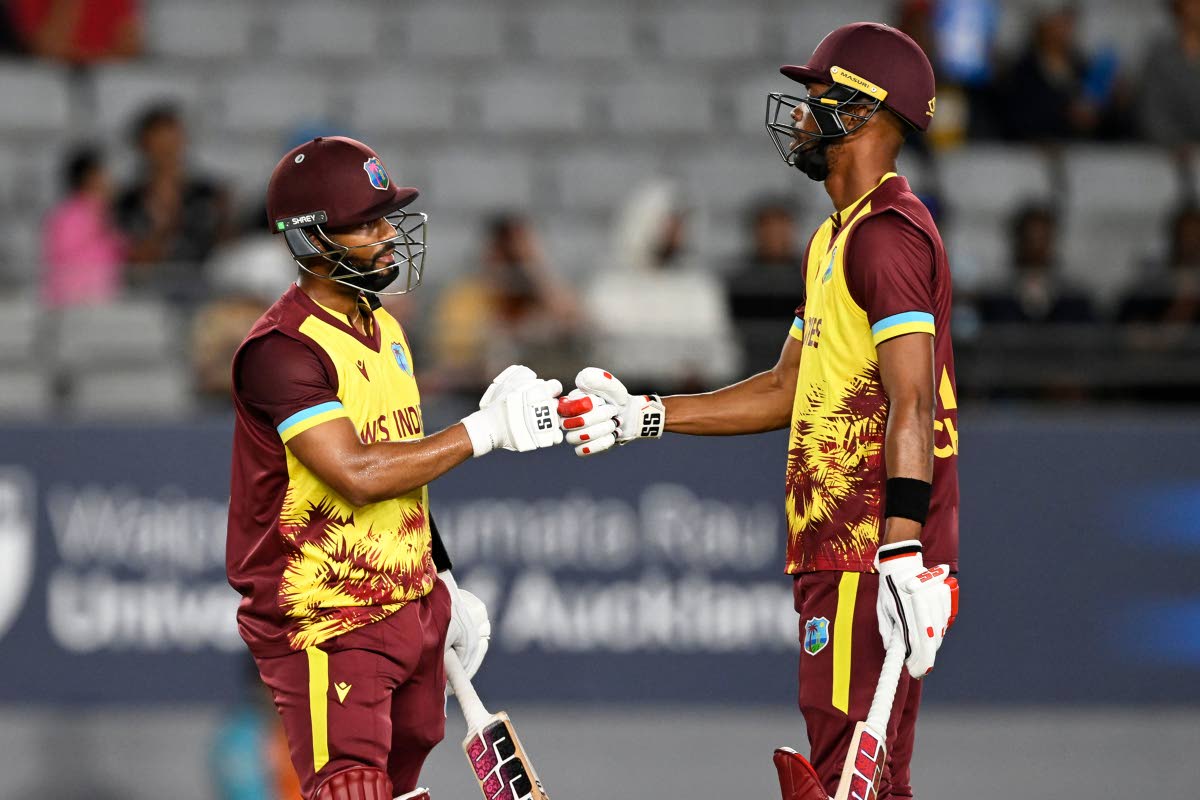 West Indies’ captain Shai Hope (left) and Roston Chase bump fists after reaching a 50-run partnership during the first T20 International cricket match of a five-game series against New Zealand, at Eden Park in Auckland, New Zealand yesterday.