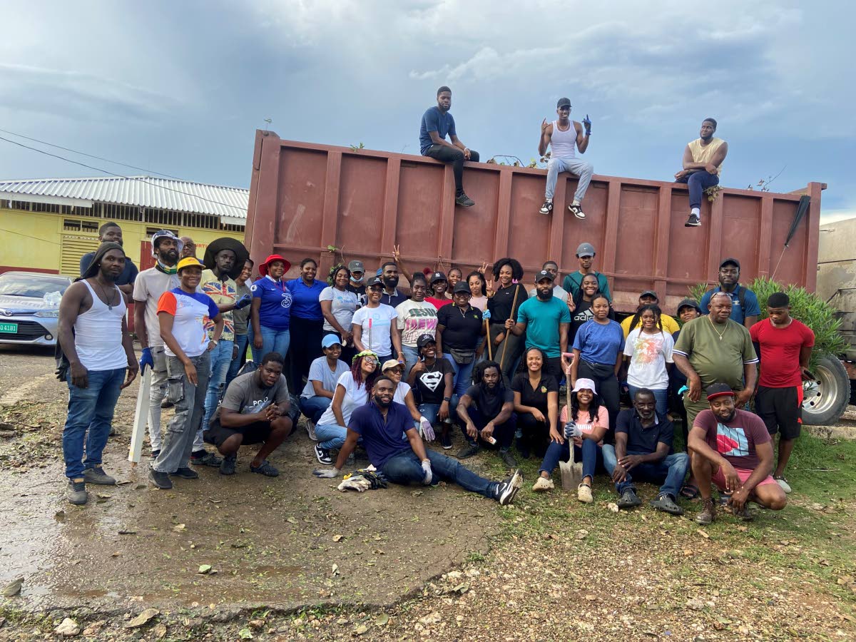 The Lucky Clover Foundation volunteers pose in front of a truck full of debris after cleaning the Runaway Bay Primary and Infant School in St Ann.