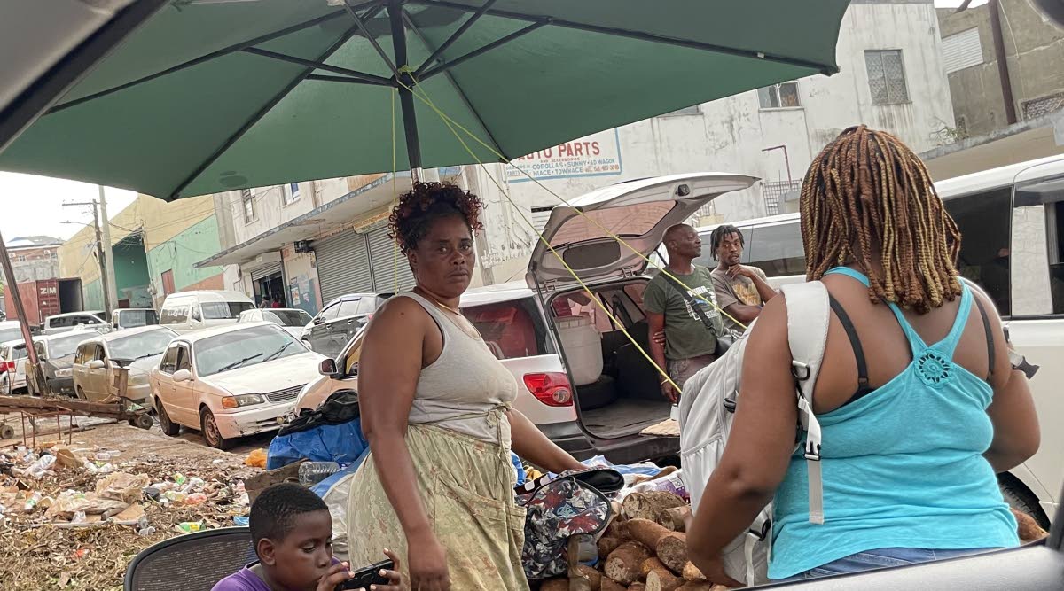 Yam seller Tesha Davis (left) negotiating the price of the produce with a customer.