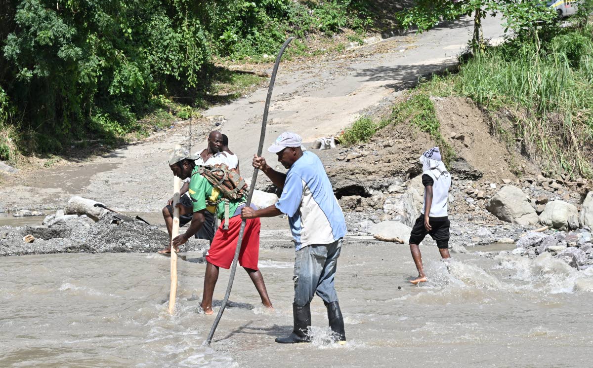 Residents working last week to clear the Robertsfield bridge in Mavis Bank, St Andrew.