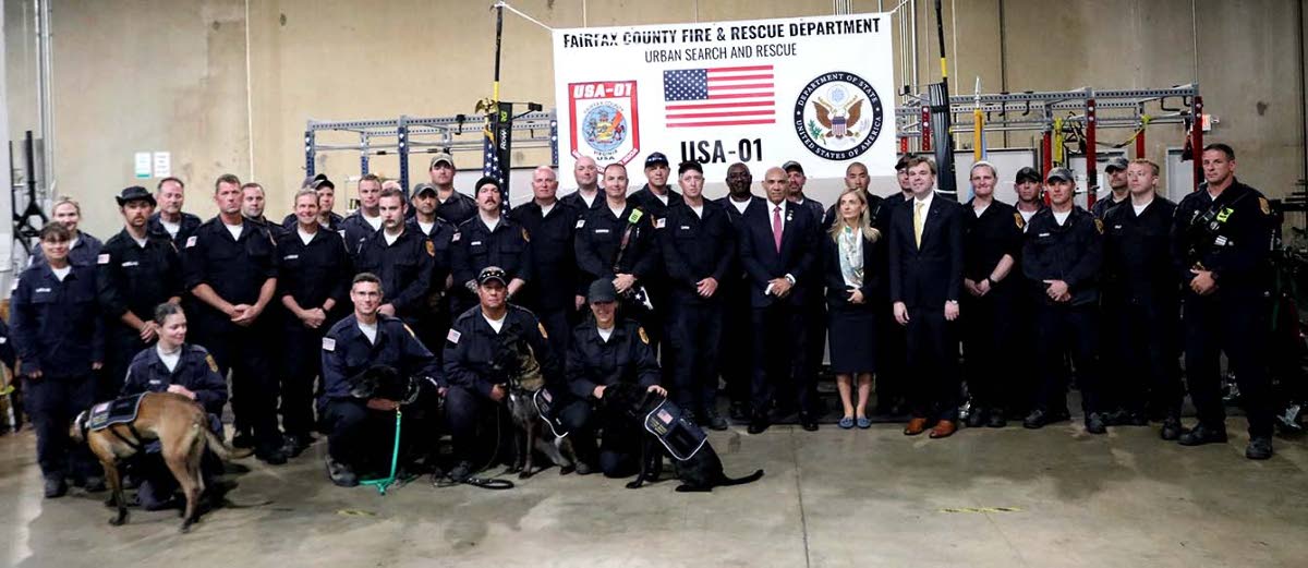 Ambassador Antony Anderson, along with Under Secretary of State for Public Diplomacy, Sarah B. Rogers (both centre) share a light moment with members of the Fairfax County Urban Search and Rescue team on their return from Jamaica at a reception at their Fa