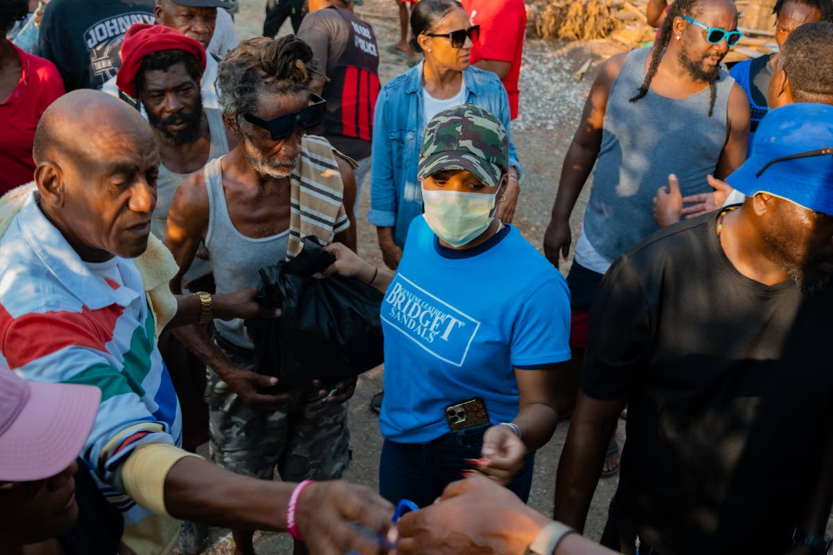 A Bridget Sandals volunteer assists with handing out care packages in Petersfield, Westmoreland. 