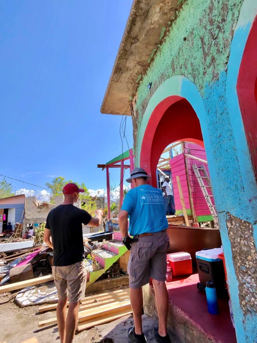 Rob Barkema, Advisory Board Member of the Issa Trust Foundation, with volunteer Dirk Bartolazzi examining Couples Swept Away employee Tishon Wilson’s destroyed home in Frome, Westmoreland, after which it was fully repaired, with just windows remaining to