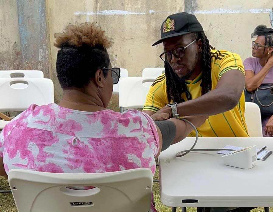 Dr Aujae Dixon check the blood pressure of a woman on a recent medical mission in western Jamaica.