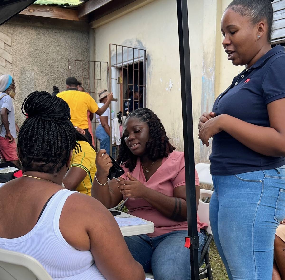 Dr Sydney Gray (seated) and Dr Abigail Boyd (standing) speak with a patient during a recent medical mission to Melissa-ravaged communities in western Jamaica.