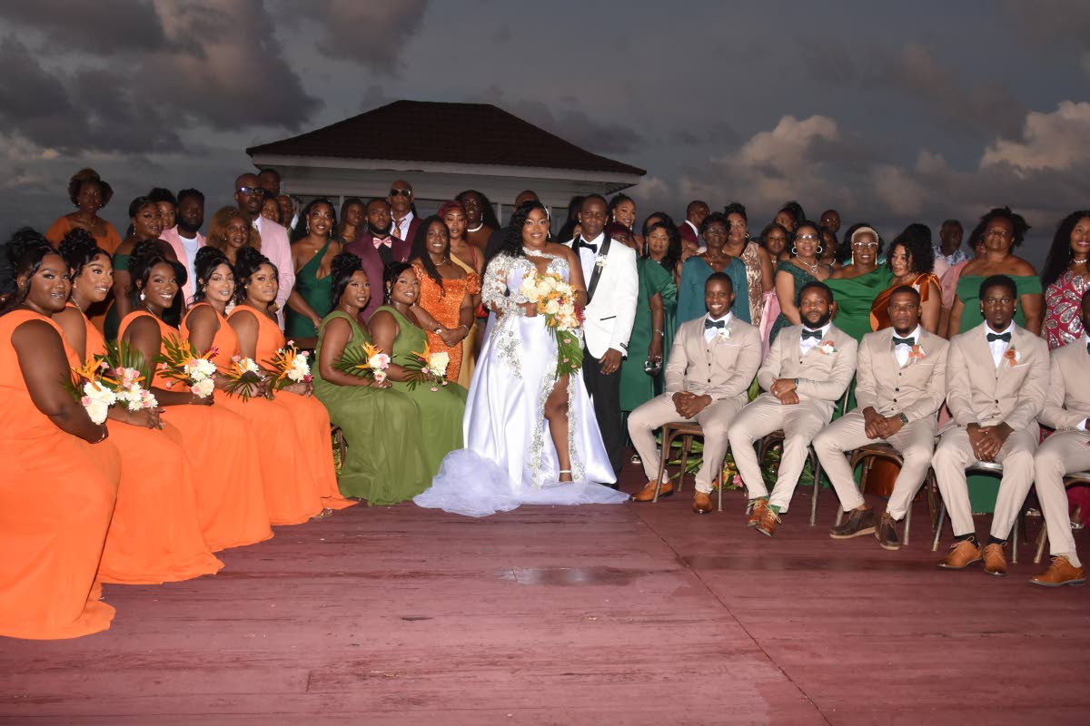 The newly-weds (centre) share lens time with their wedding party, family and friends at the Waters Edge Guest House in Unity Hall, St James. 