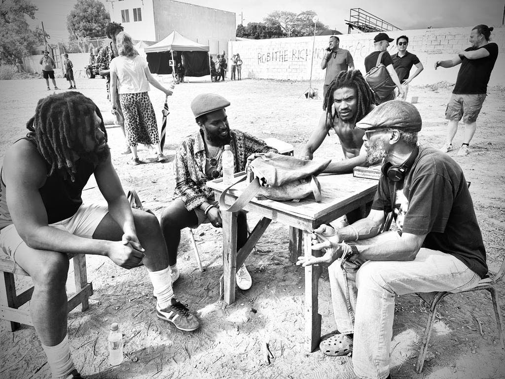 Shepherd (second right) on set of the Bob Marley biopic ‘One Love’ in Trench Town in December 2023 with the late graphic designer and Marley confidante Neville Garrick (right), whom the actor portrayed in the film. Also pictured are Gawaine Campbell (l