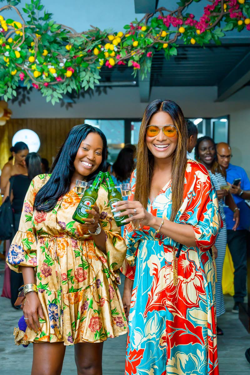 Shantell Hill-Afonso (left), marketing manager at Sunshine Snacks, and Head of Leep Marketing, Tanya Lee Perkins, make a Heineken toast to the success of Mezza Luna’s grand opening.