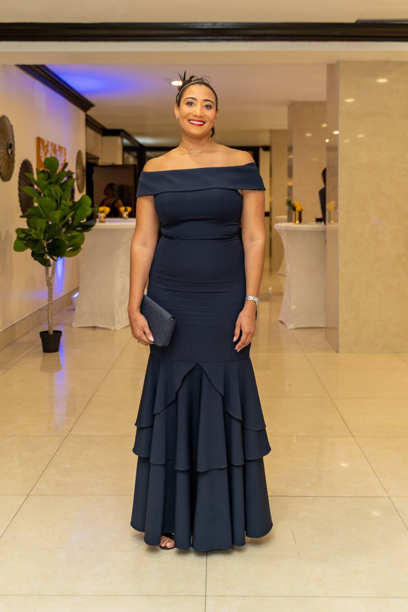 Christina Millington, assistant vice president of investment banking at GK Capital Management, dons an off-the-shoulder dress paired with a matching clutch.
