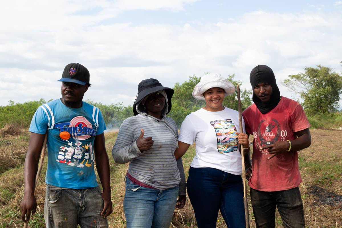 Latoya Burrows-Johns (second right), owner of LD Promise Farms, shares a photo with employees (from left) Kenroy Ricketts, Vivine Haslam and Glen Shirley.