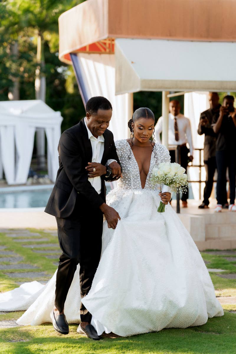 A vision of perfection, this stunning bride is happy to be escorted up the aisle by her father, Radcliffe Titus.  