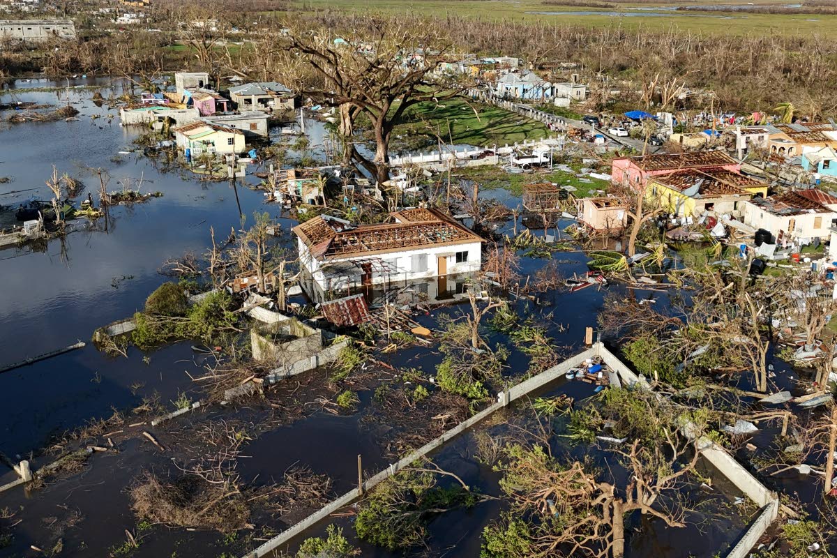 Debris surrounds damaged homes along the Black River on October 30 in the aftermath of Hurricane Melissa. 