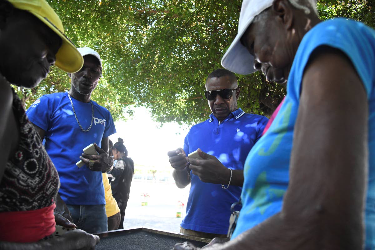 Mayor Andrew Swaby (third from left) plays a game of dominoes with, from left: Beverley Cargill; Cavan Gooden and Esmerilda Graham the St. William Grant Park in Kingston on January 1, 2025.