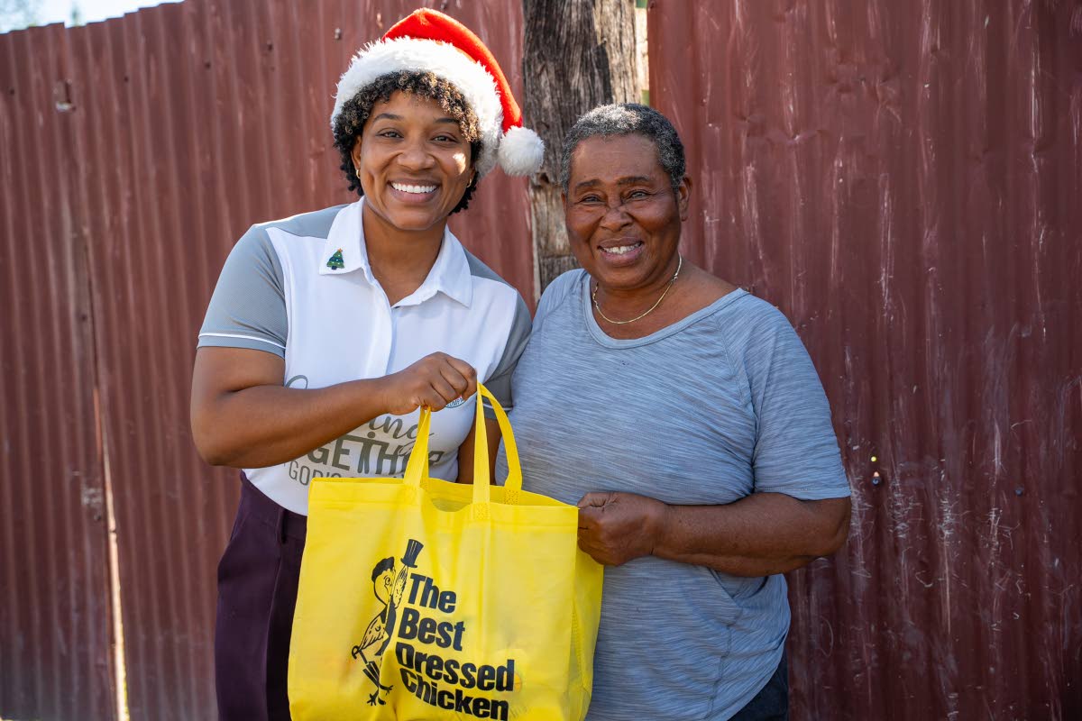 All smiles from Moya Williams (right) of the McCook’s Pen community as she receives her Best Dressed Chicken goodie bag from Loren Lee (left), internal communications & engagement officer at Jamaica Broilers Group, during the company’s recent outreach 