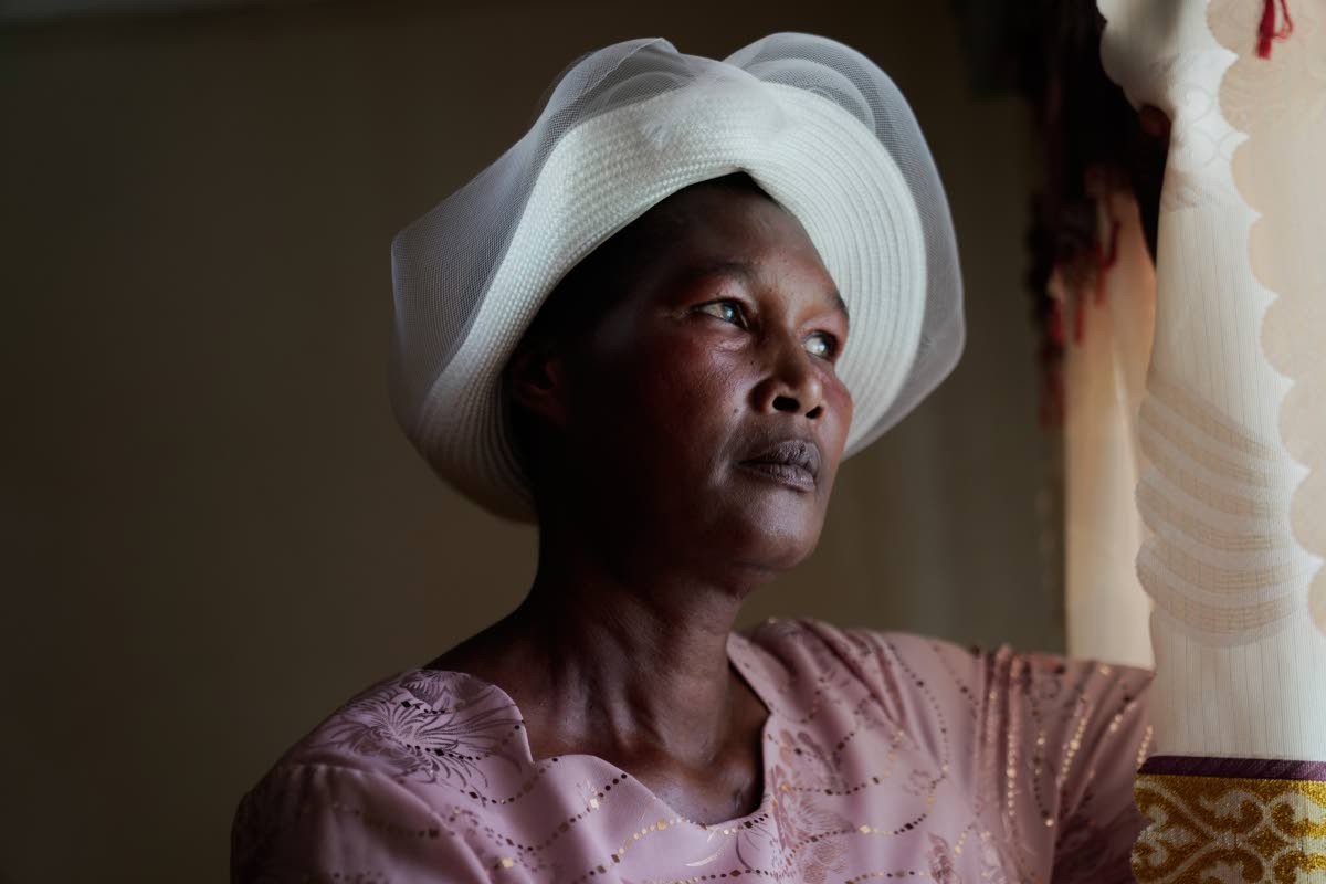 Anne Bonareri, a widow, looks out the window of her home in Kisii, Kenya.