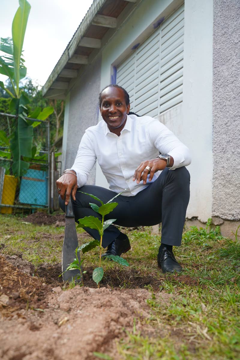  State Minister in the Ministry of Foreign Affairs and Foreign Trade Alando Terrelonge proudly poses with his planted coffee seedling on the grounds of the Guava Ridge Basic School during a planting exercise on Jamaica Blue Mountain Coffee Day on Friday. 