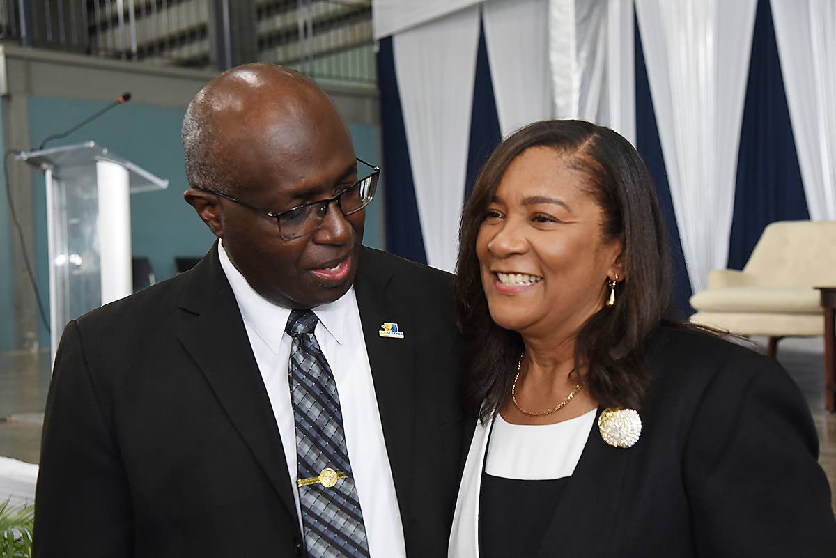 Gary Allen, group senior executive, corporate and external affairs at the RJRGLEANER Communications Group, whispers words of encouragement to Karen Smith, wife of Anthony Smith, former Group CEO, during yesterday’s thanksgiving service for his life insid