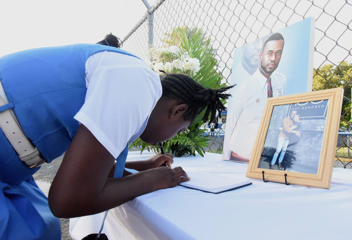 A Jessie Ripoll Primary School student signs the condolence book during devotions, following the death of principal Oneil Stevens and his wife Camesha Lindsay-Stevens in a motor vehicle accident in the United States in January 2025.