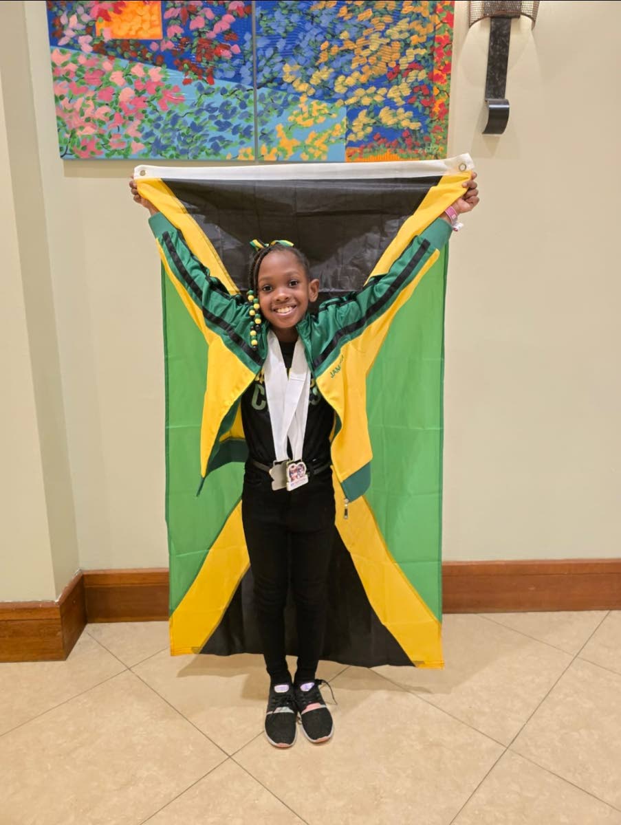 Seven-year-old chess prodigy Je’Nasiya Mais proudly displays the Jamaica flag,  posing with her gold and silver medals from the 2025 Central American and Caribbean Youth Chess Festival in Puerto Rico, recently.