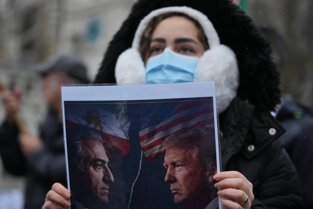 A protester holds up a poster showing Iran’s exiled crown prince Reza Pahlavi, (left) and US President Donald Trump, as she demonstrates outside the House of Parliament, in London.