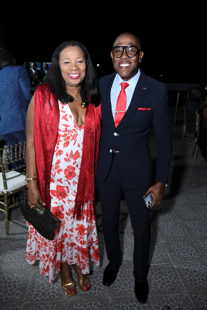 Complementing each other in red is Custos of St Andrew, Ian Forbes and his wife, Lana.
