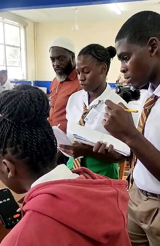 Manchester High physics teacher Christopher Taylor (left) looks on as his students (from right) Tonadria Branford, Jadan Hyatt and Nickacia Thompson prepare to conduct laboratory tests at the University of the West Indies (UWI) Department of Science and Te