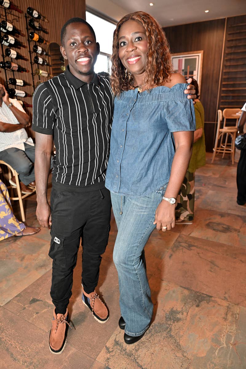 Kayann Ricketts of Scotiabank poses alongside Sagicor Sigma Run 2026 patron, World Champion Oblique Seville.