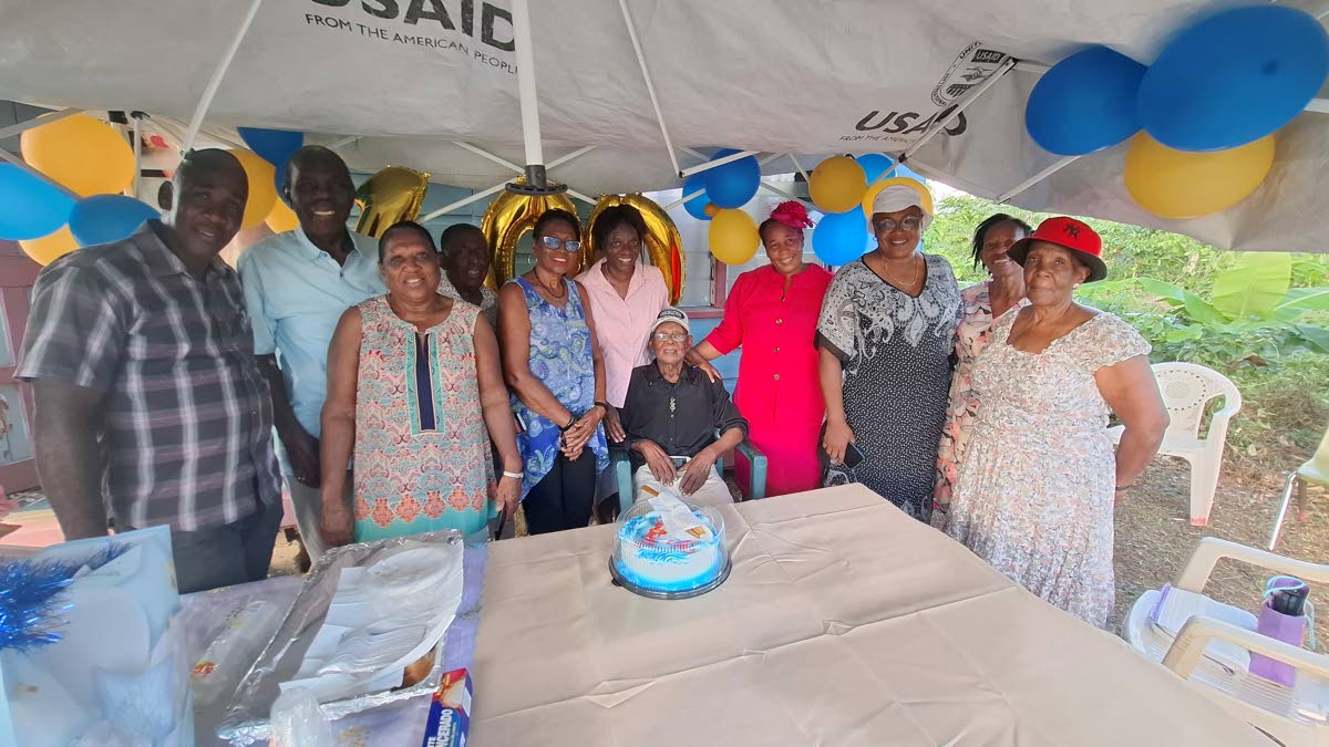 Centenarian Isaiah Freckleton (centre) with family and community members during his 100th birthday celebration in Big Bridge, Westmoreland.