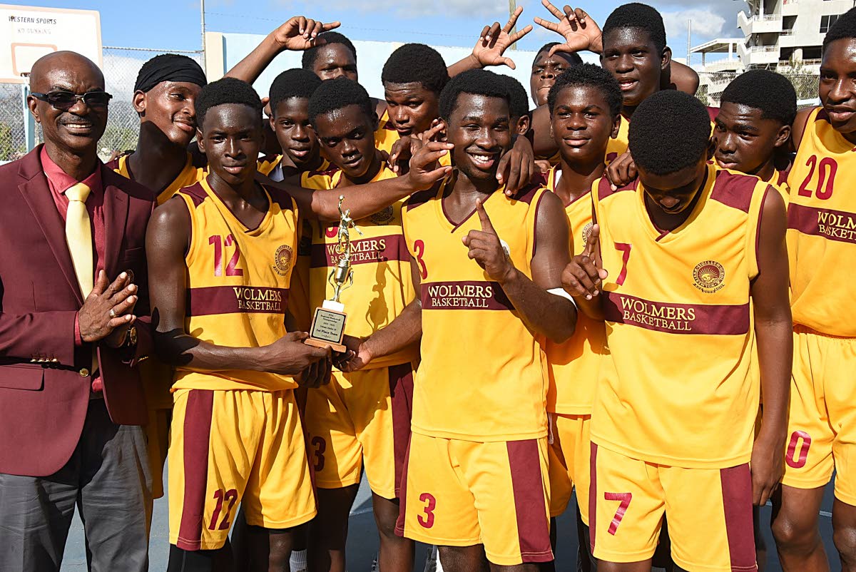 Wolmer’s Boys’ School coach, Howard Harvey (left), celebrates with his charges after winning the ISSA Under-16 Urban Schoolboy Basketball title at St George’s College yesterday.