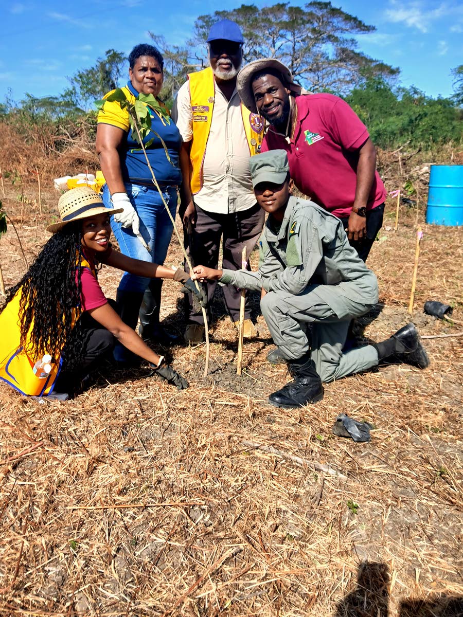 Andrew Hinds (right), forest manager at the Forestry Department (South East Region) joins volunteers from Jamaica 4-H Clubs, Jamaica Combined Cadet Force and Lions Club of Portmore for a photo moment after planting a tree in Innswood, St Catherine on Frida